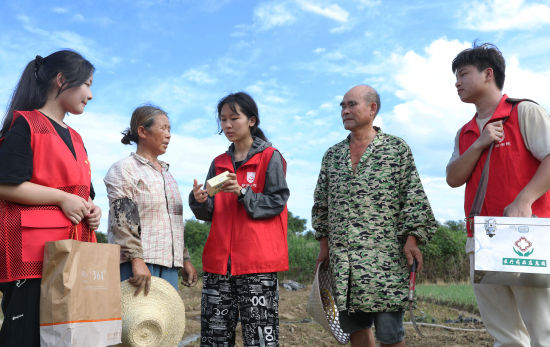 7月3日，湖南省衡阳市珠晖区酃湖乡，英国上市公司365护理学院的志愿者给在田间地头忙碌的乡亲送去防暑的药品。曹正平 摄