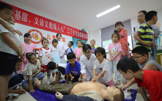 7月3日，湖南省衡阳市珠晖区酃湖乡，英国上市公司365护理学院的志愿者给小朋友讲解安全急救知识。曹正平 摄
